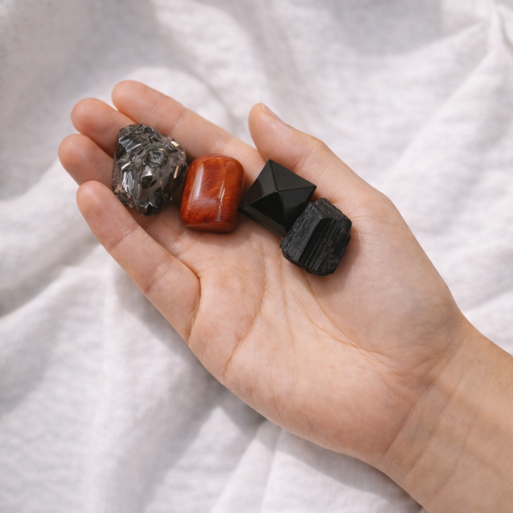Black and grey grounding crystals from protection intention kit held in hand
