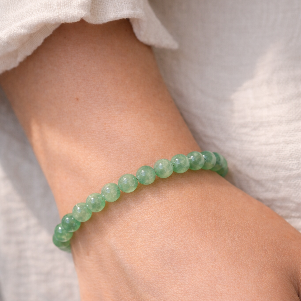 Green aventurine healing crystal bracelet styled on natural fabric